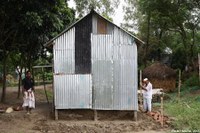 Deux hommes construisent une maison sur l'île de Savar après avoir quitté leur village inondé par la crue du Brahmapoutre