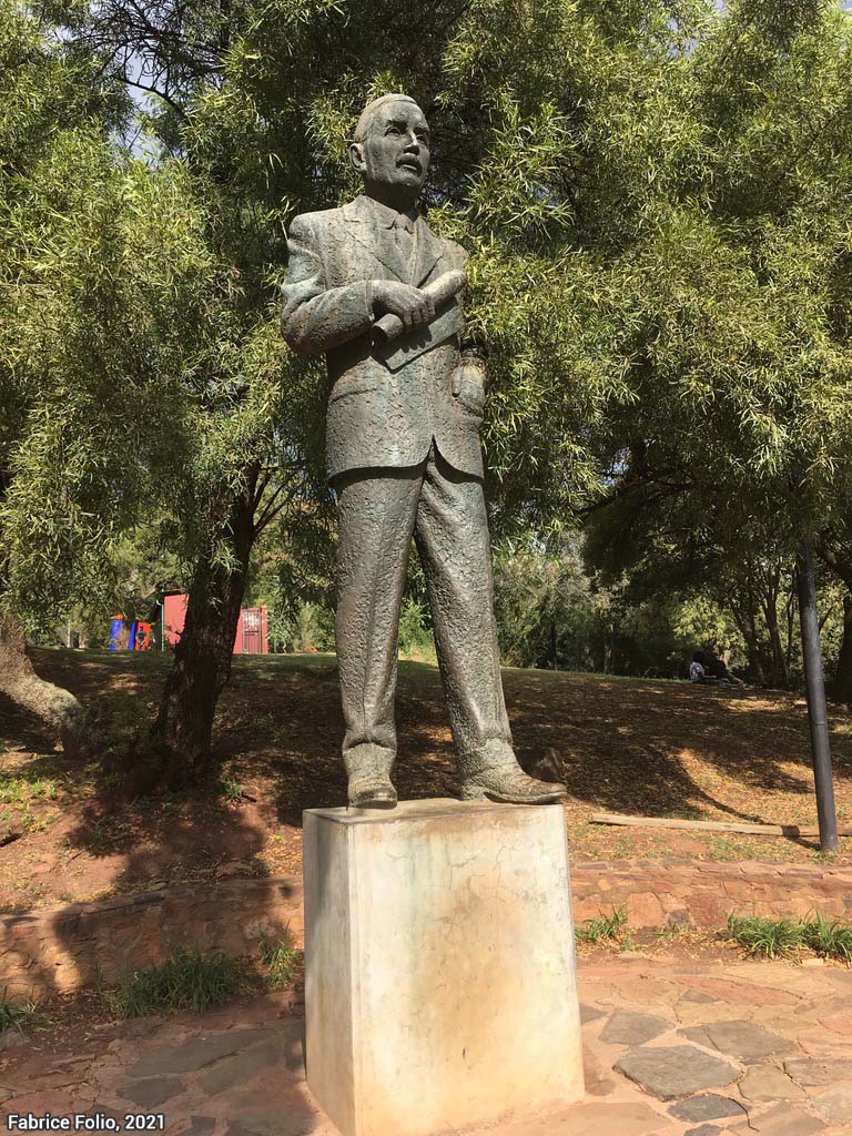À droite, la statue de Johannes Albertus Hertzog au-devant du palais présidentiel à Pretoria, excentrée et anonymisée sur la droite du jardin. Hertzog